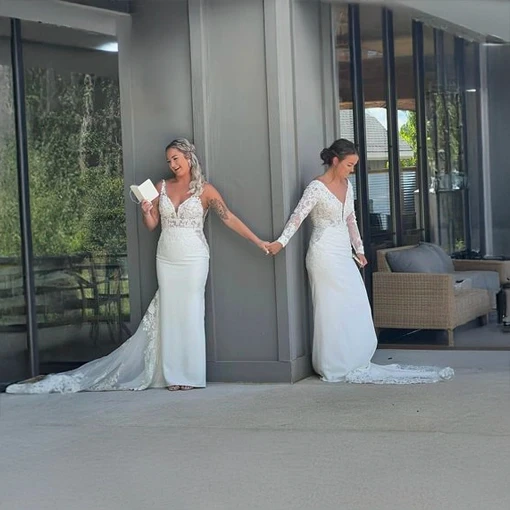 Two brides by a window on their wedding day in Indianapolis